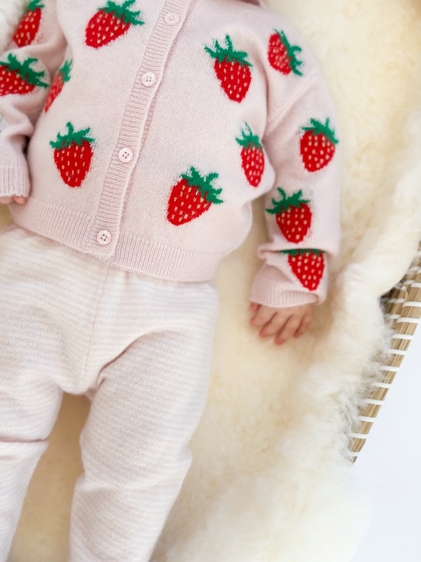 Detail Baby in Strickjacke mit Erbeer-Intarsien