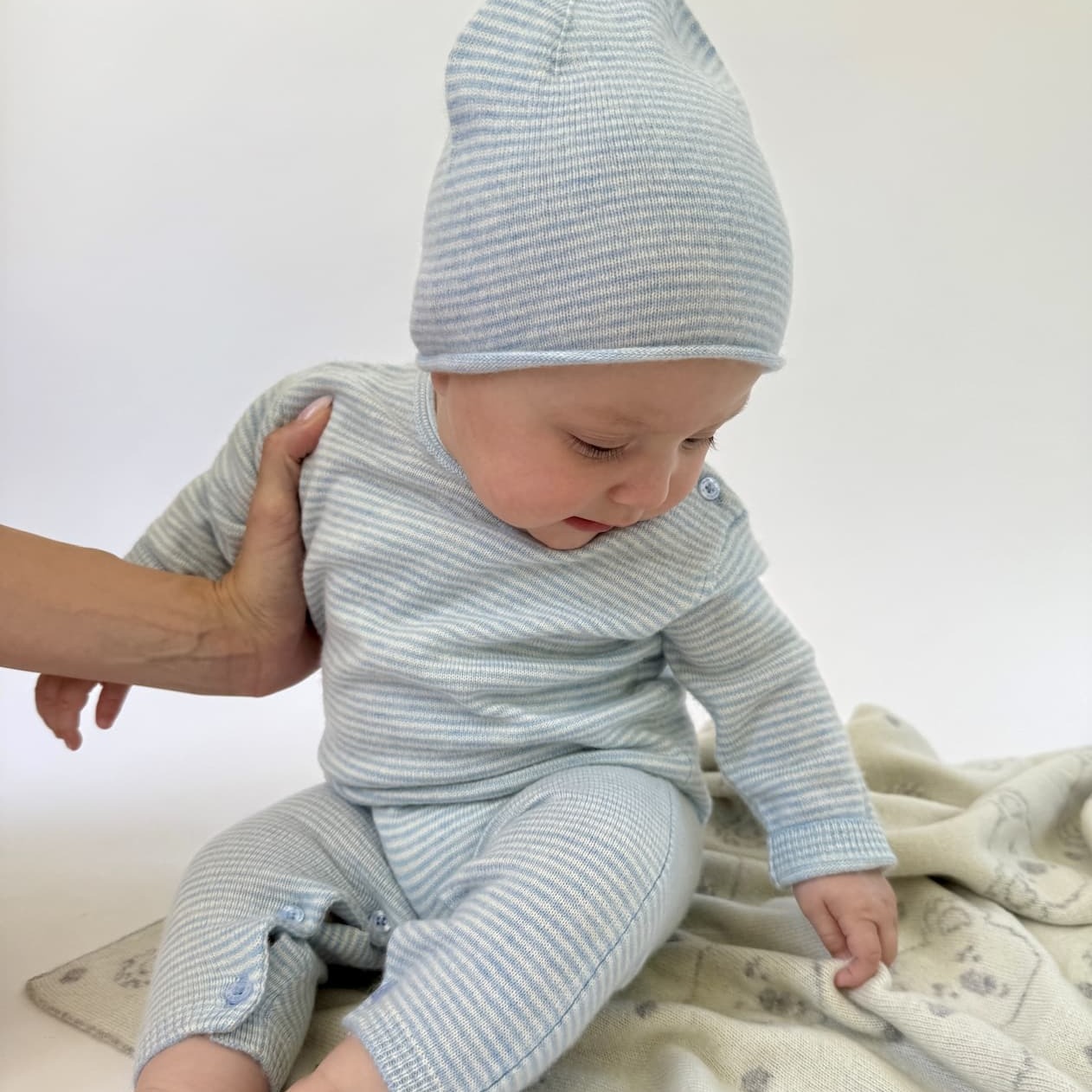 Baby sitzend mit Overall und Mütze MINISTRIPE