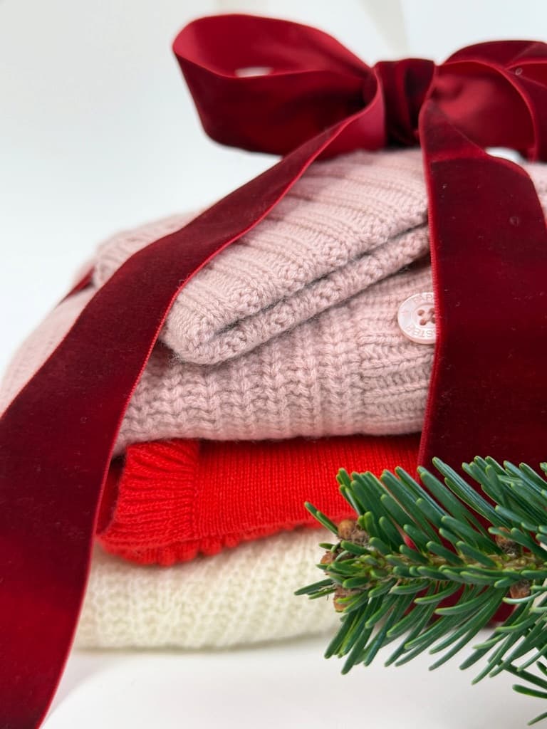 Kaschmirstapel mit Geschenkschleife weihnachtlich dekoriert
