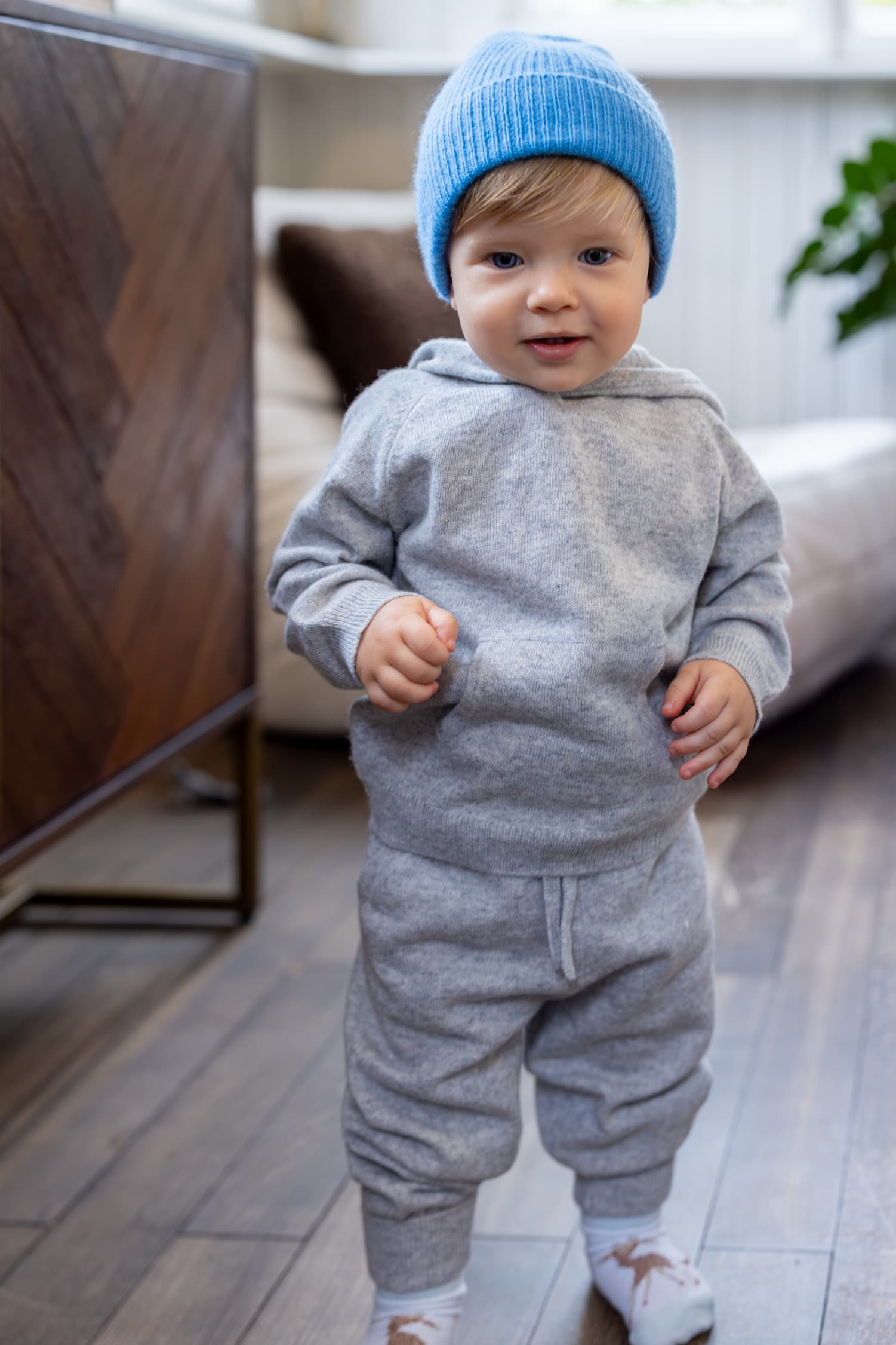 Kleiner Junge in hellgrauem Kaschmiroutfit