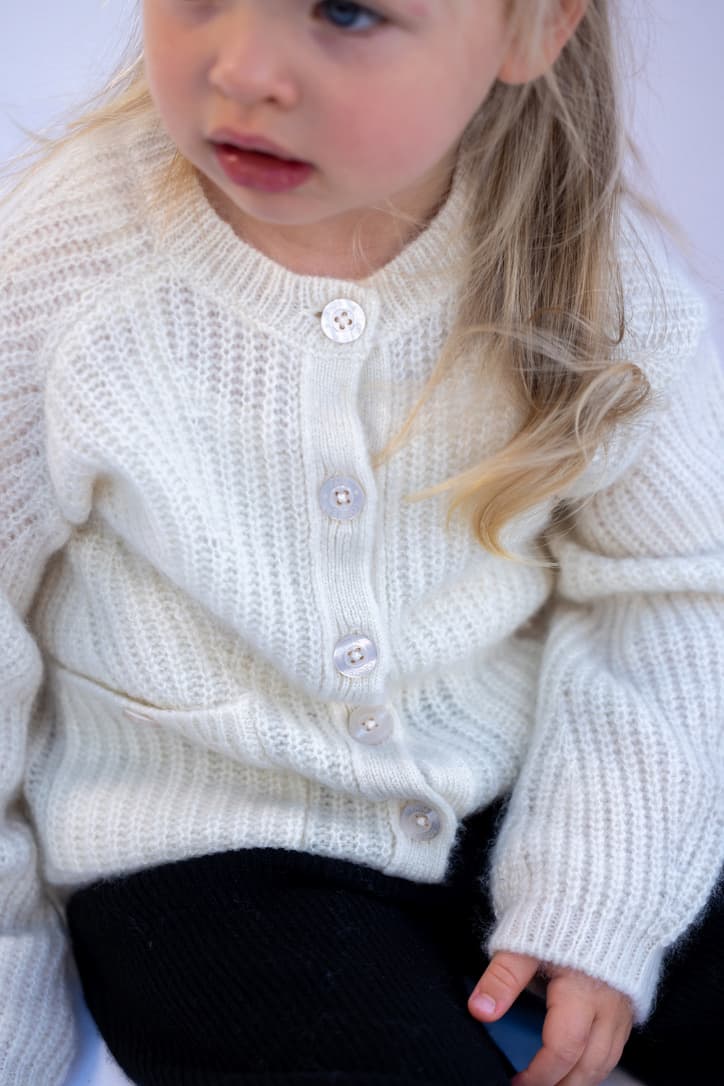 Kleines Mädchen (Ausschnitt) sitzend in Kaschmiroutfit