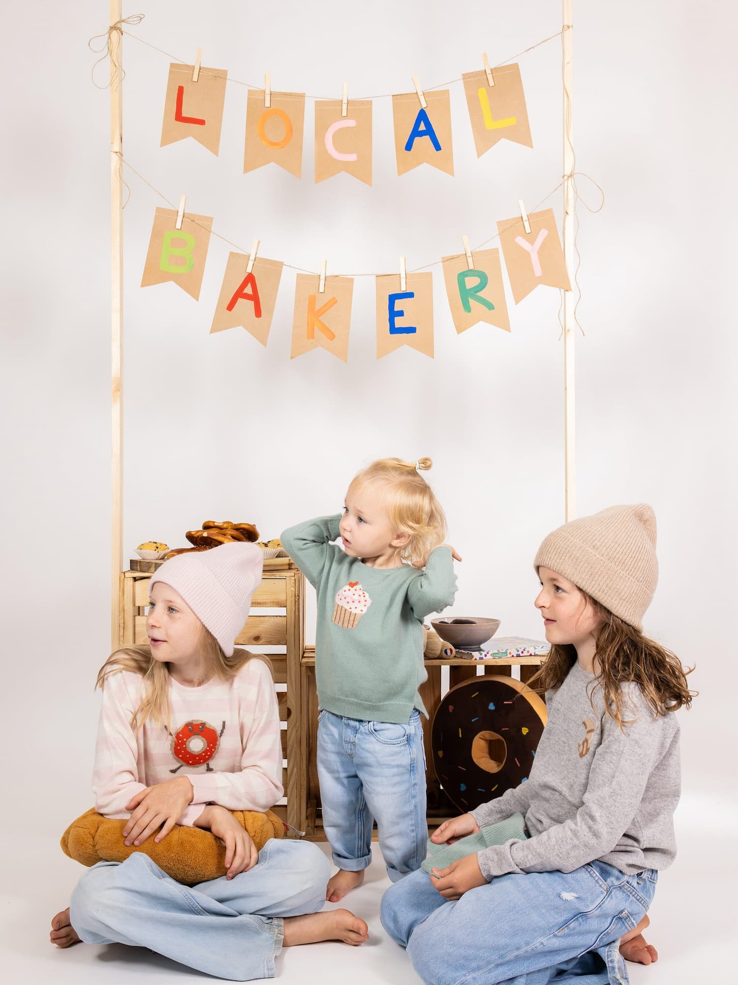 Drei Kinder sitzend und stehend mit Kaschmir-Outfits