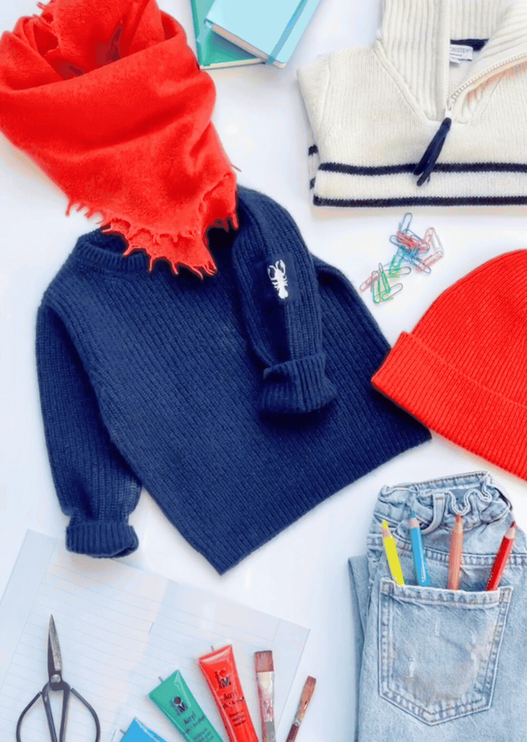 Cover: Stilleben mit Kaschmirpullover, -Mütze und -Schal und Schuluntensilien