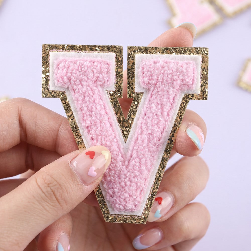 Close-up of pink chenille varsity letter patch with gold glitter border