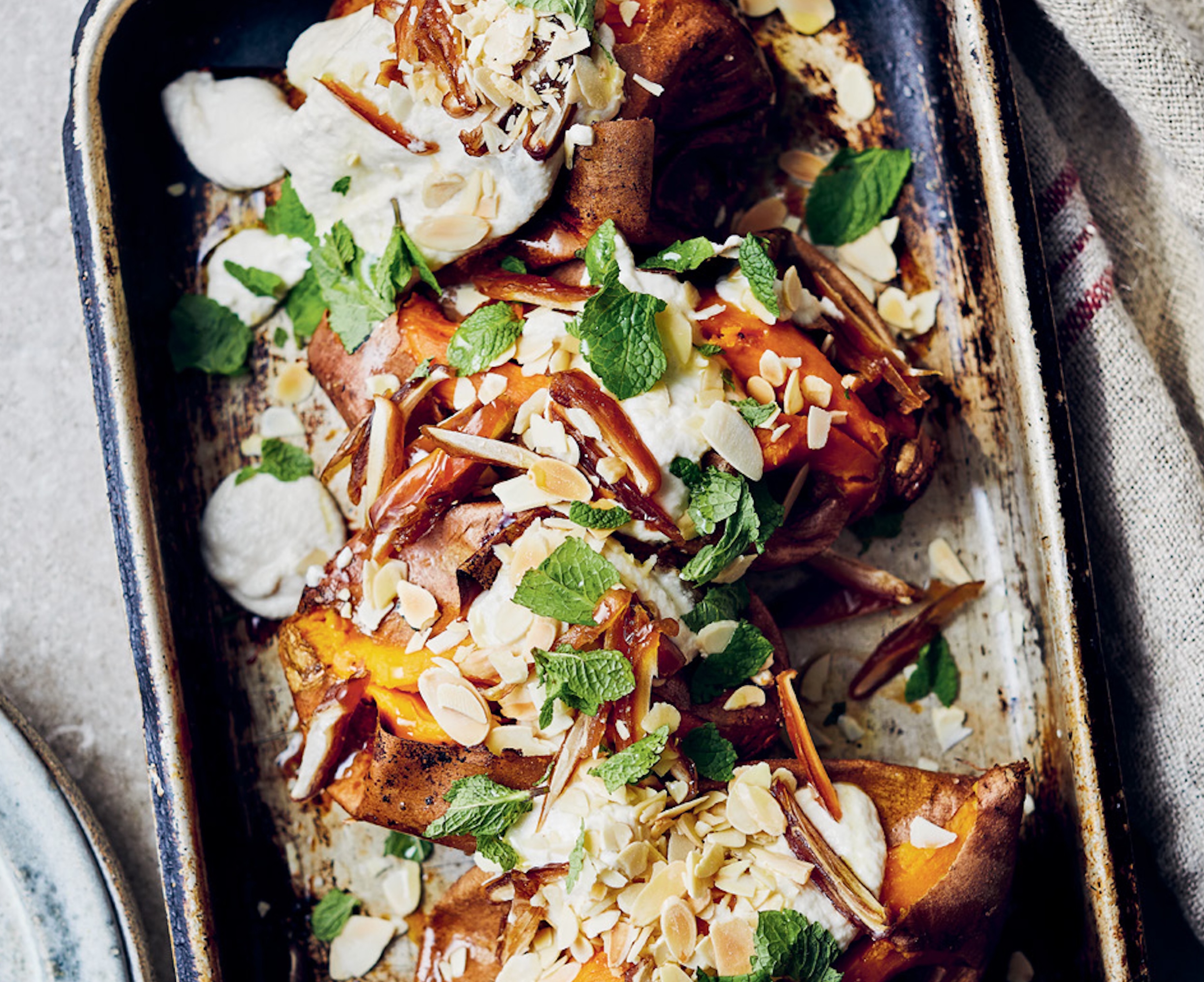 A delicious dish of sweet potatoes with almond sauce, dates and chopped mint 