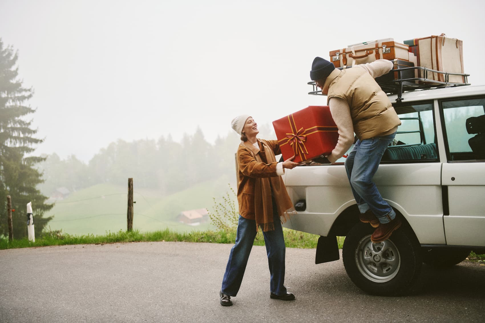 Et miljøbilde av en skjorte med slips brettet på et bord med spillekort, terninger, avis og briller