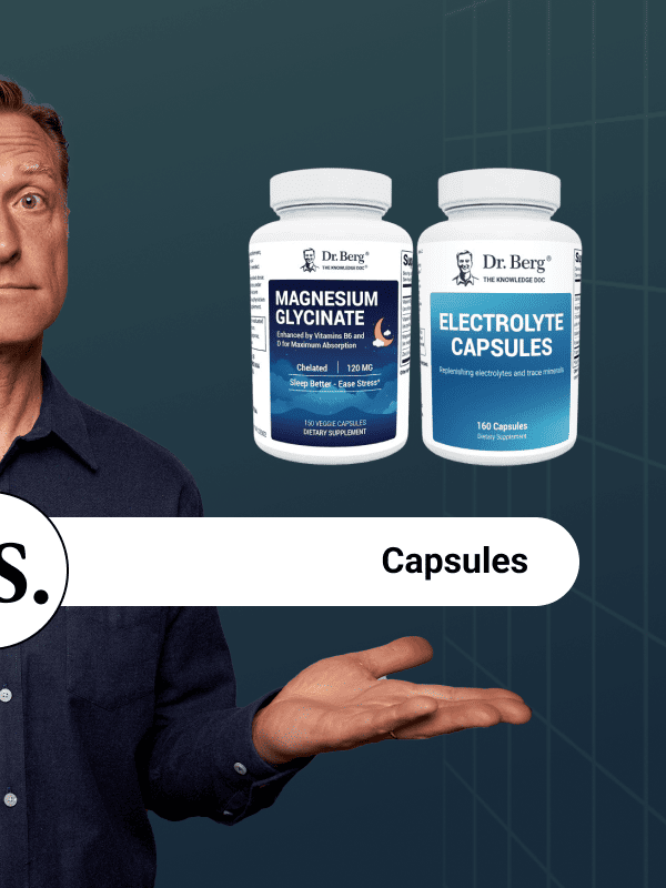 Dr. Berg pointing at capsule options for magnesium and electrolyte.