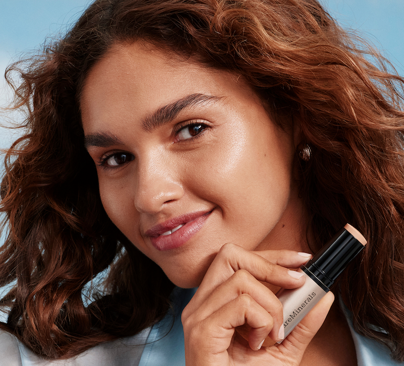 Model holding Complexion rescue luminous skin tint stick