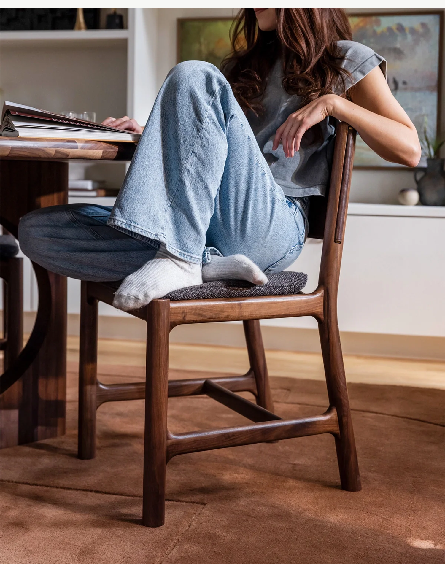 Image of a woman sitting in the Avon Dining Chair in her living room