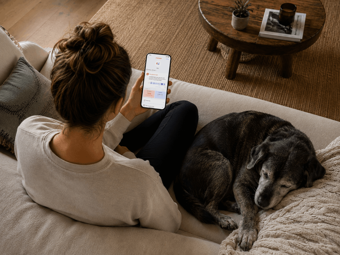 A dog parent checking the Maven Pet app on the couch