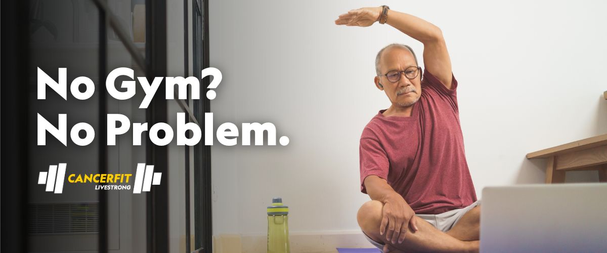 A man watching a workout video on a laptop and stretching