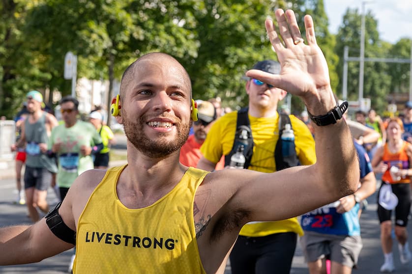 A man running in a marathon giving a high five