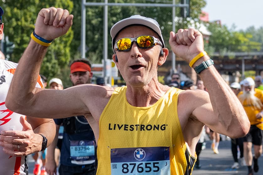A runner raising his arms and cheering