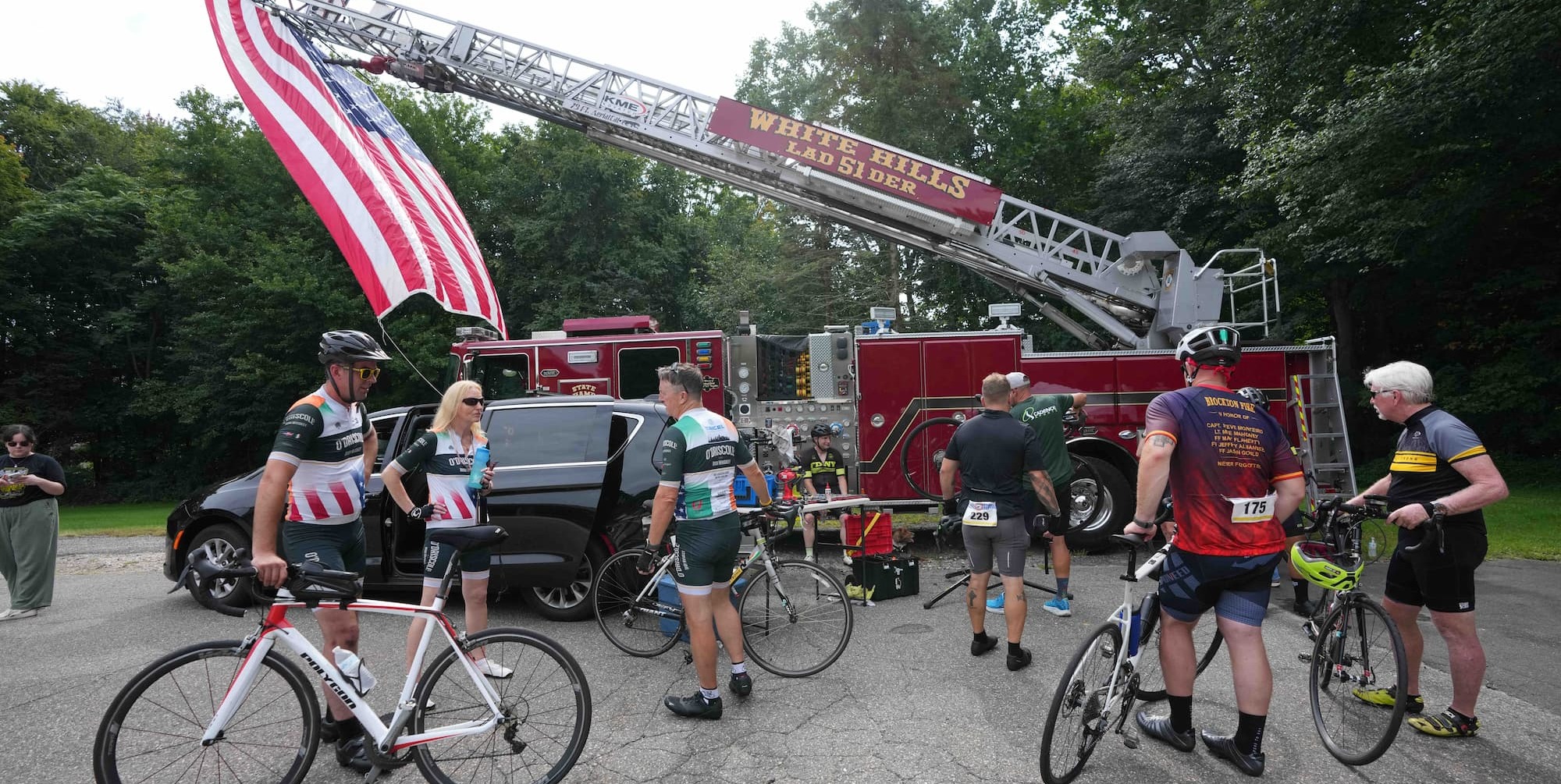 Group holding Ireland flag in front of fire truck