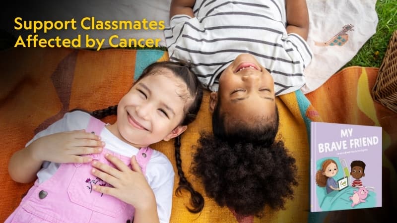 Two children laying on a blanket outside