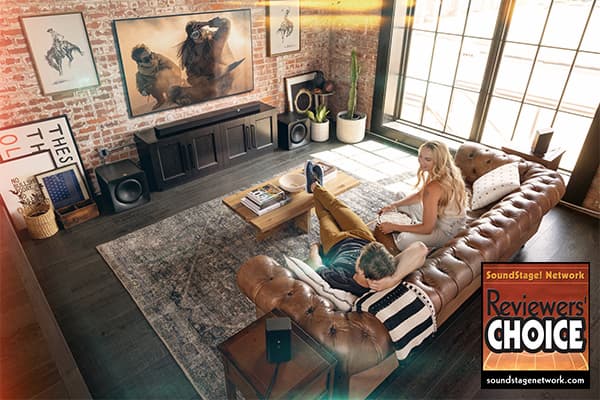 Young adults watching tv in a stylish living room, with a Flexus Core 300 sound bar, with two subwoofers.