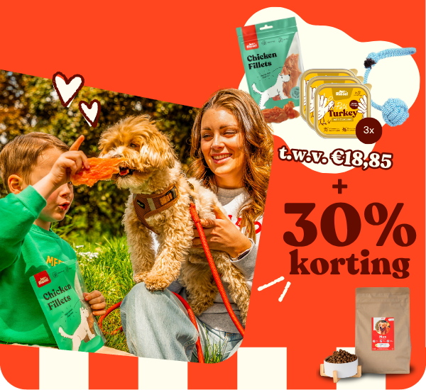 Een jonge vrouw houdt haar maltezer vast terwijl haar zoontje hem een chicken fillet geeft. Nu 3 gratis producten en 30% korting.