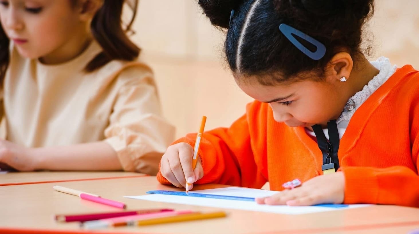 Two young children using colouring-in pencils