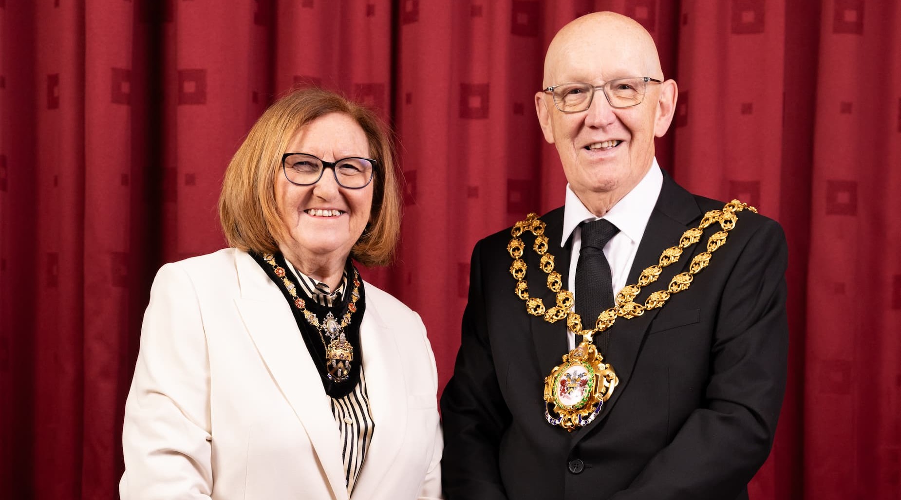 The Mayoress Kath Moores and the Mayor of Oldham Cllr Eddie Moores smiling in their mayoral chains