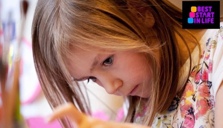 A little girl concentrating as she gets creative 