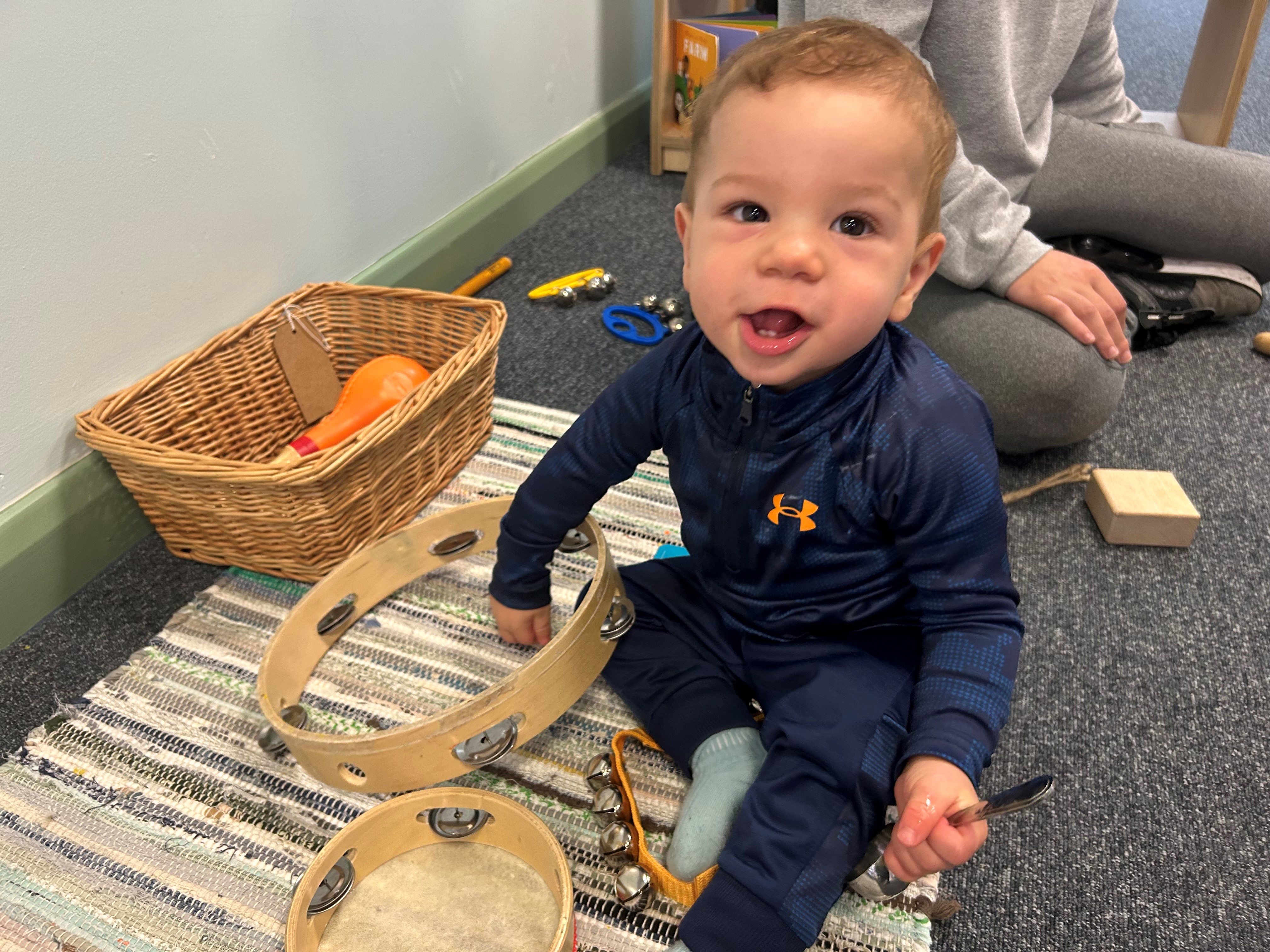 Young child with a tambourine at Beever Family Hub