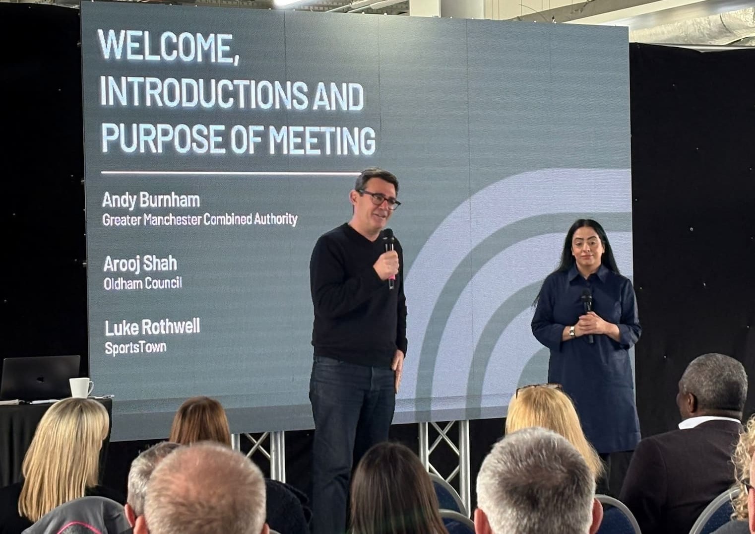 Andy Burnham and Cllr Arooj Shah presenting the SportsTown vision to an audience at Boundary Park 