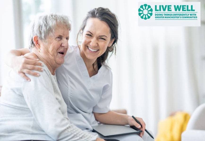 An elderly woman smiling as a younger woman smiles into the camera with her arm around her