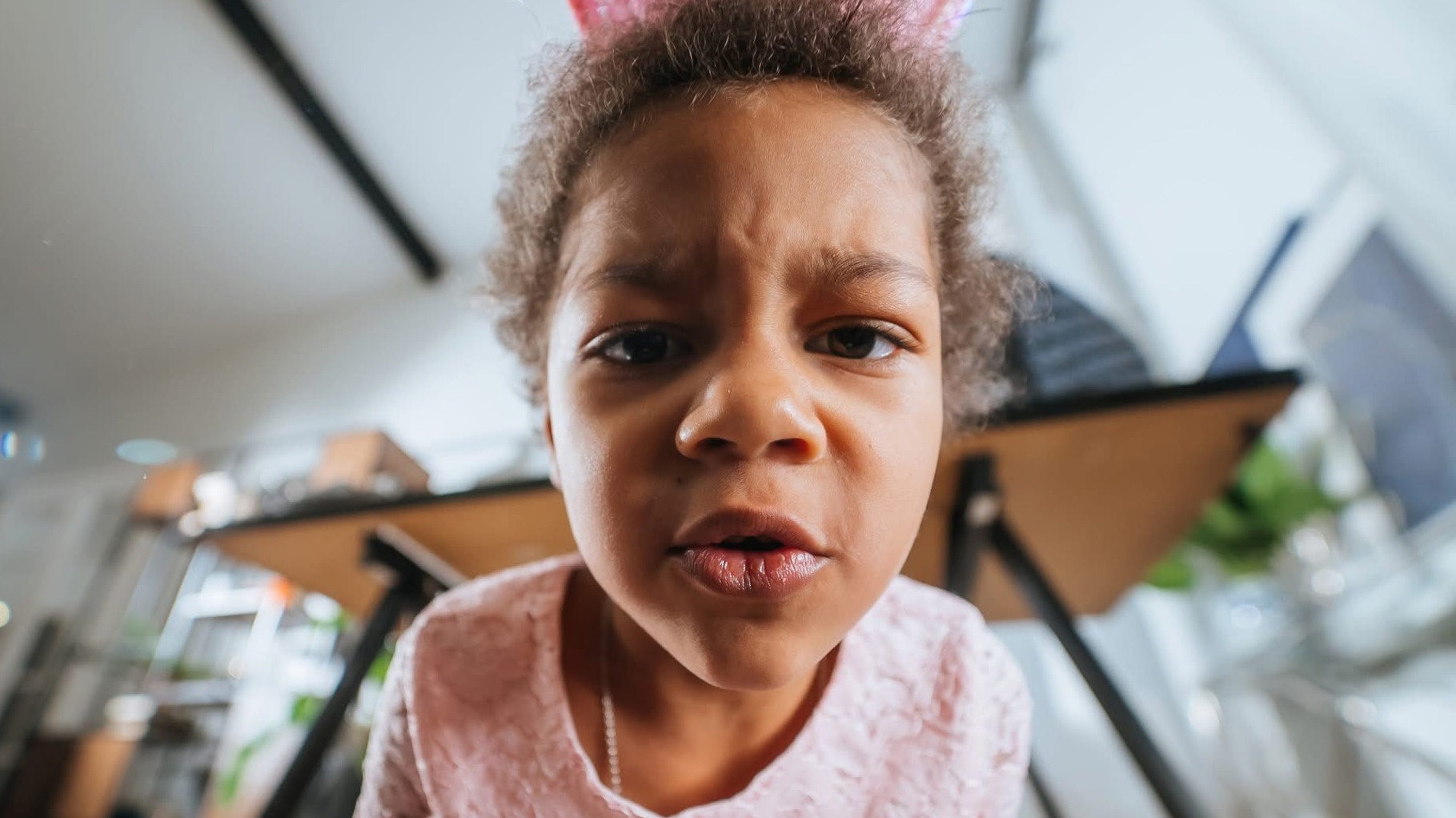 A frowning child looks confrontationally into the camera