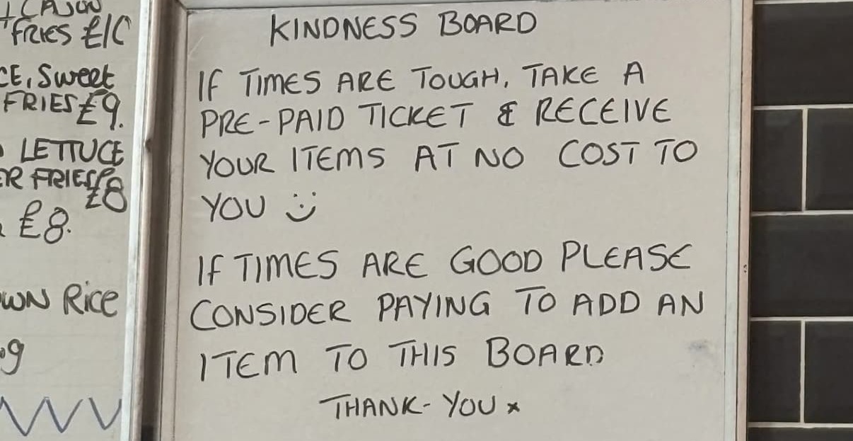 The Kindness Board at Clean Plate Kitchen with a message inviting people to consider paying for an item for someone, or taking a ticket if times are tough