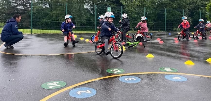 A group of small children in cycle helmets on bikes