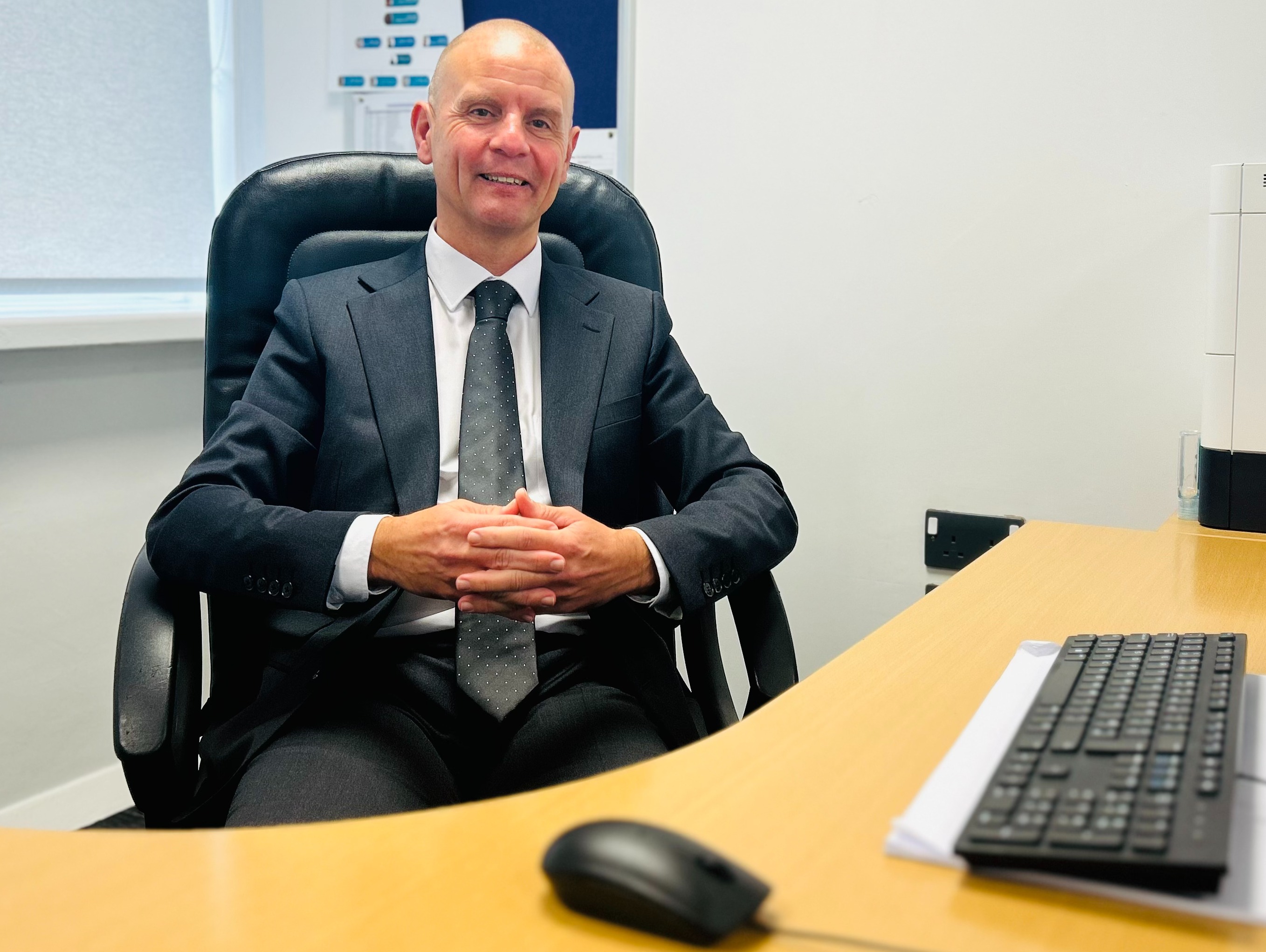 Principal Mark Giles seated behind his desk at The Hathershaw College