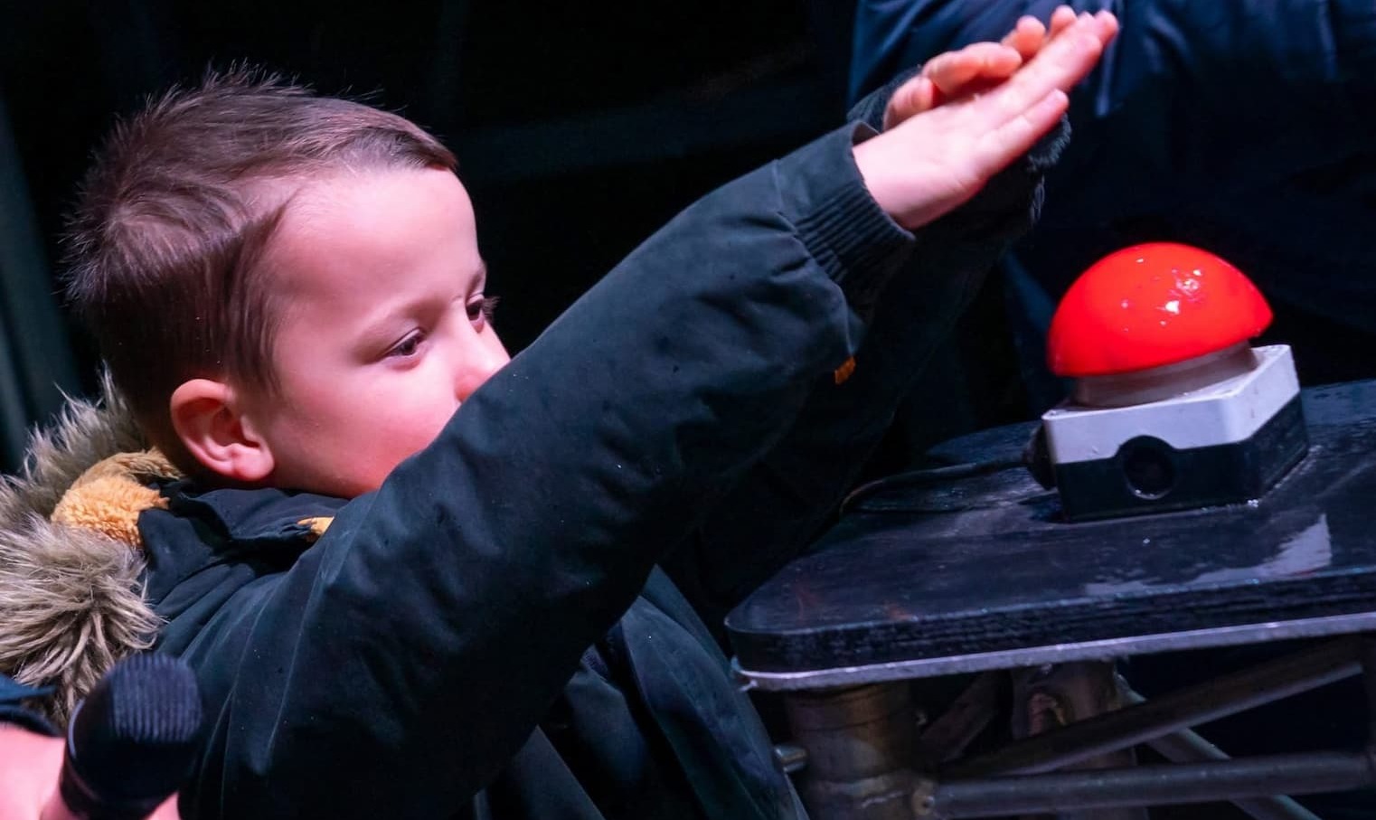 A young boy pressing button on stage