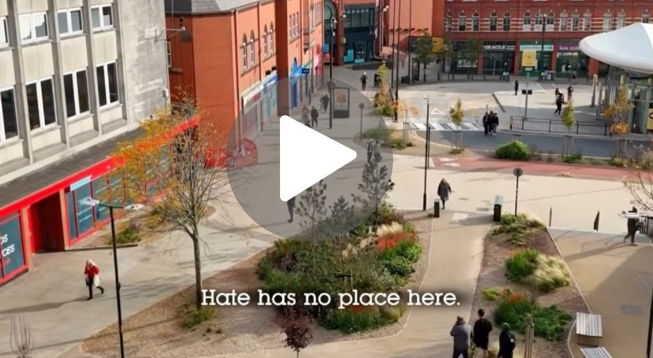 An aerial view of Oldham town centre and the words 'hate has no place' 