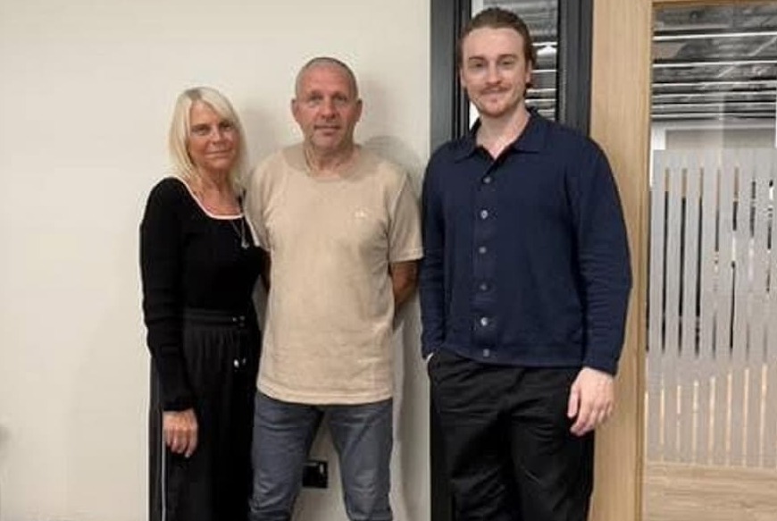Fostering couple Wendy Paul smiling as they stand alongside The Oldham Cast podcast presenter Robin Marshall  