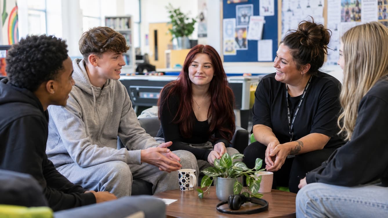 A group of young people seated chatting around a table