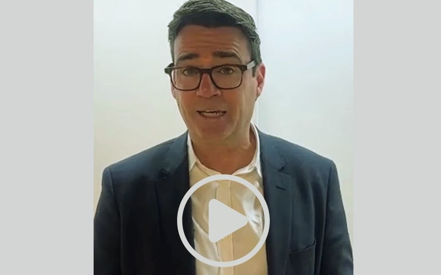 Andy Burnham speaking in a smart suit jacket and white shirt