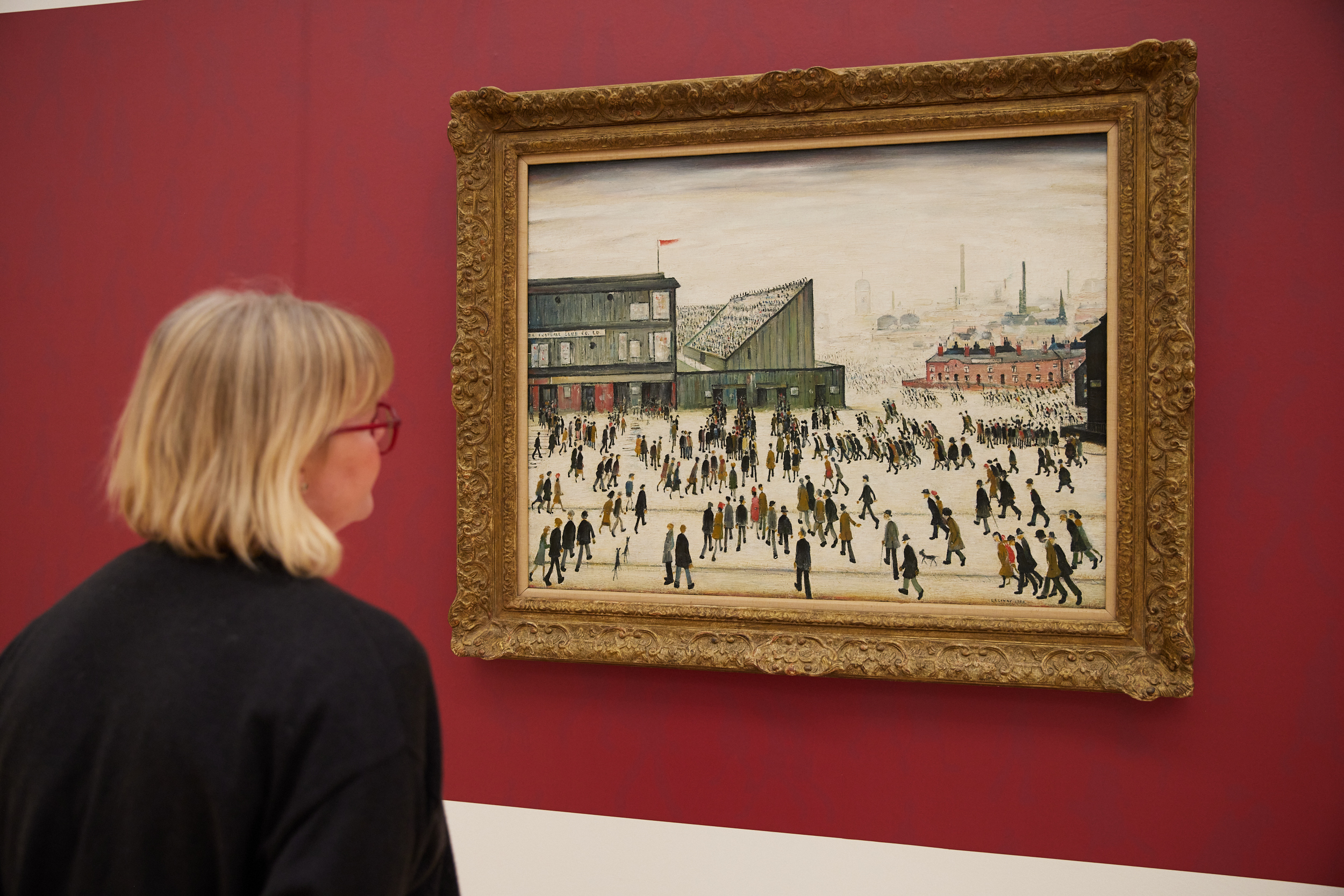 Person looking at L S Lowry's 'Going to the Match'