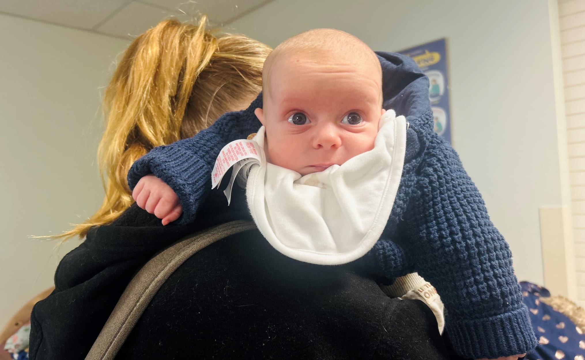 A parent holding her little boy at the Winter Wardrobe event