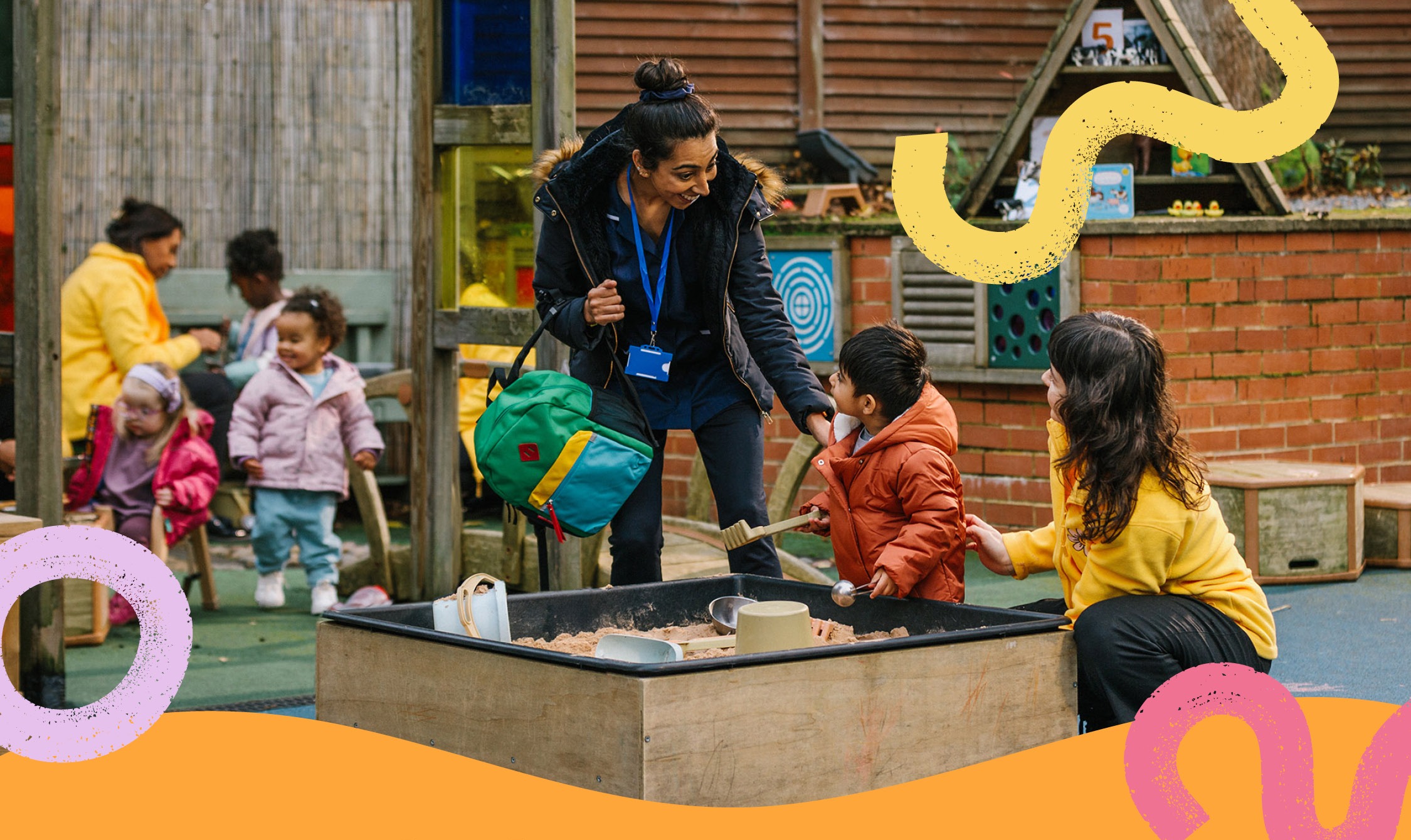 Smiling person engaging with young children in a play area 