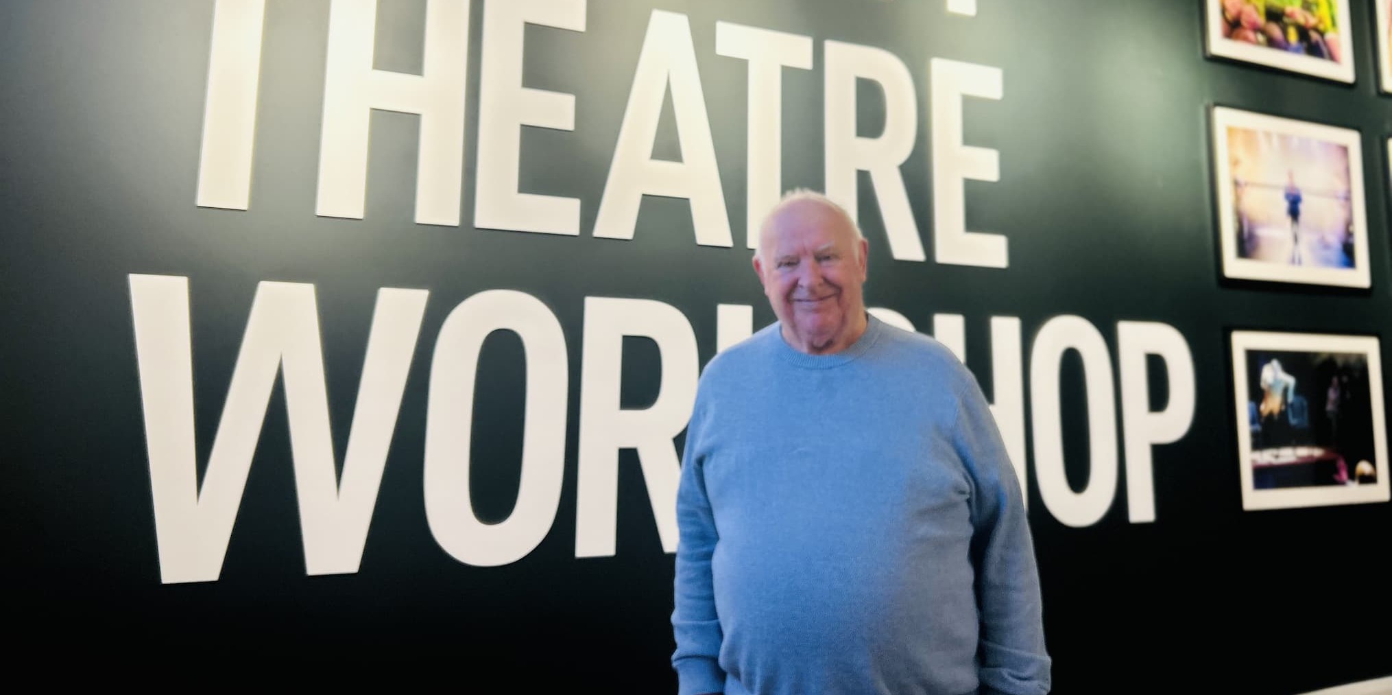 Cllr Peter Dean in front of Oldham Theatre Workshop sign