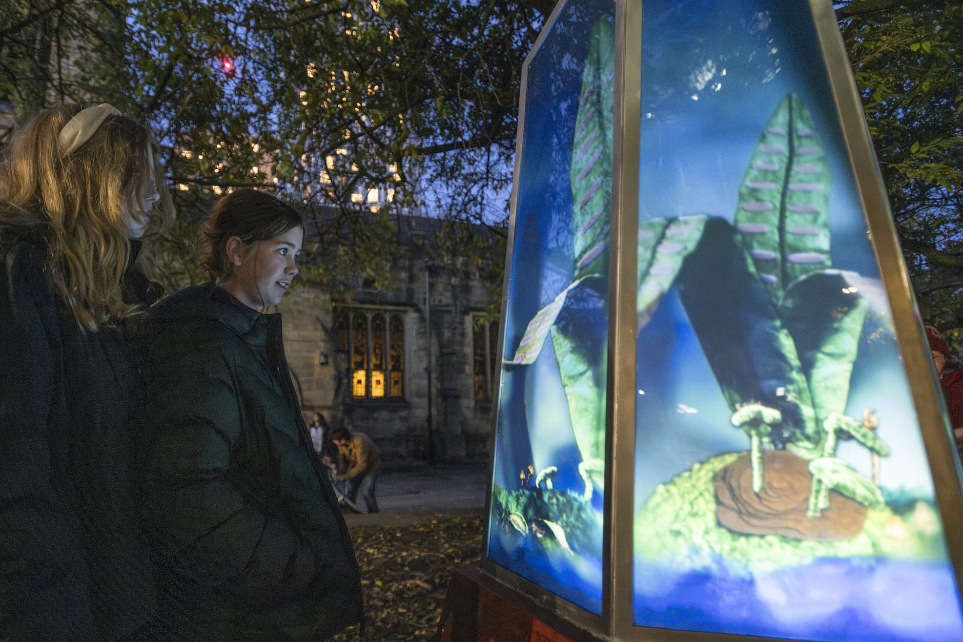 Two young people looking at an illuminated display 