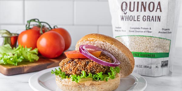 Healthy Quinoa Veggie Burger sitting on a white plate on a white countertop 