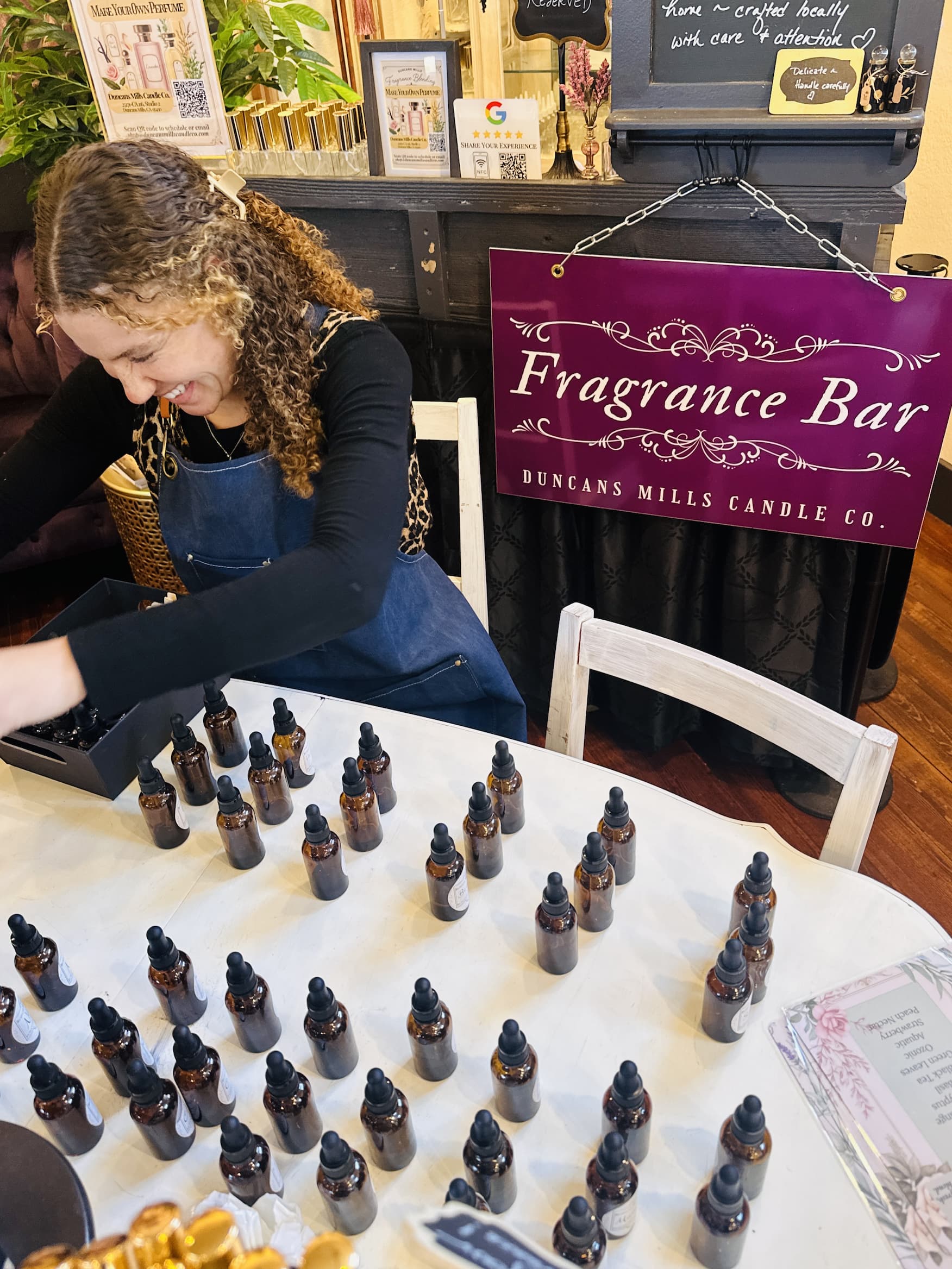The Fragrance Bar at Duncans Mills Candle Co. — dozens of amber dropper bottles arranged on the working table