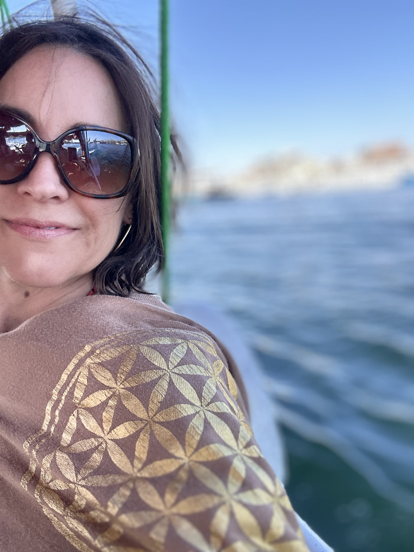 Stephanie on the Nile, Flower of Life shawl close-up, river light behind
