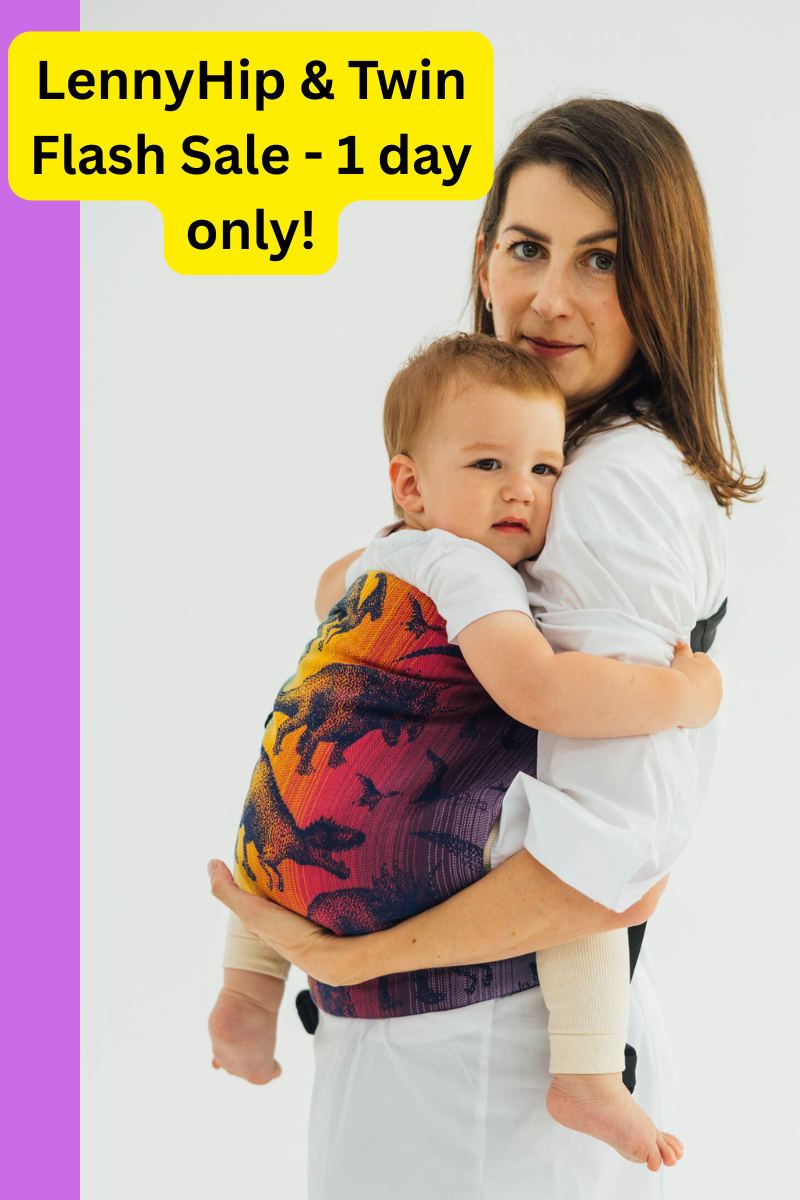 "LennyHip & Twin Flash Sale - 1 day only!" shows model holding her baby in LennyHip carrier in Jurassic Park - New Era "LennyHip & Twin Flash Sale - 1 day only!" shows model holding her baby in LennyHip carrier in Jurassic Park - New Era