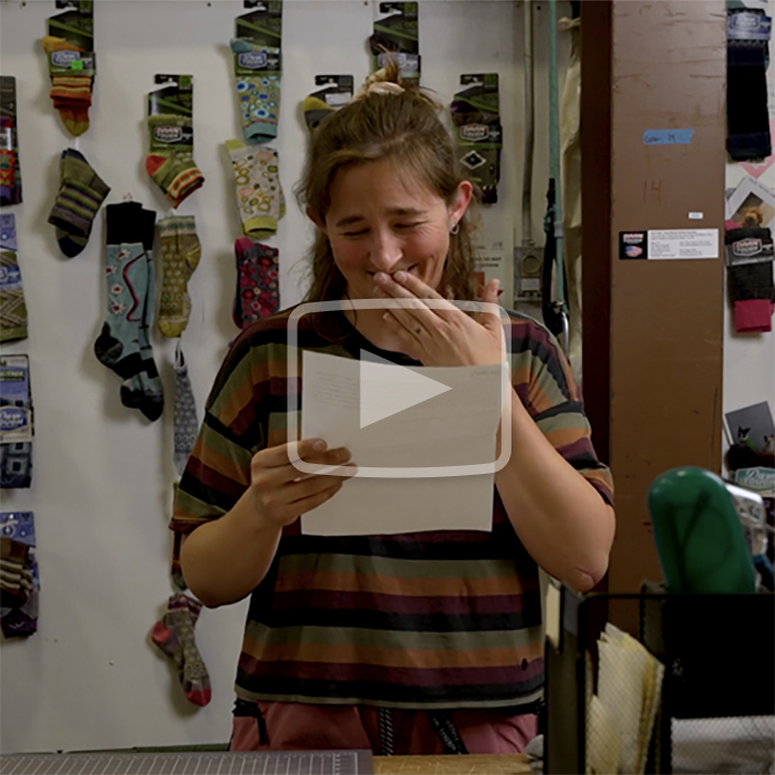 Play the video - a warranty specialist laughs while holding a letter
