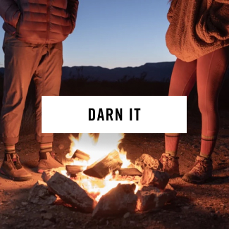 Read Darn It - two people stand around a glowing campfire at dusk