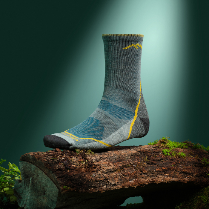 Shop Micro Crew Socks - a Light Hiker Micro Crew sits on a log against a glowing teal background