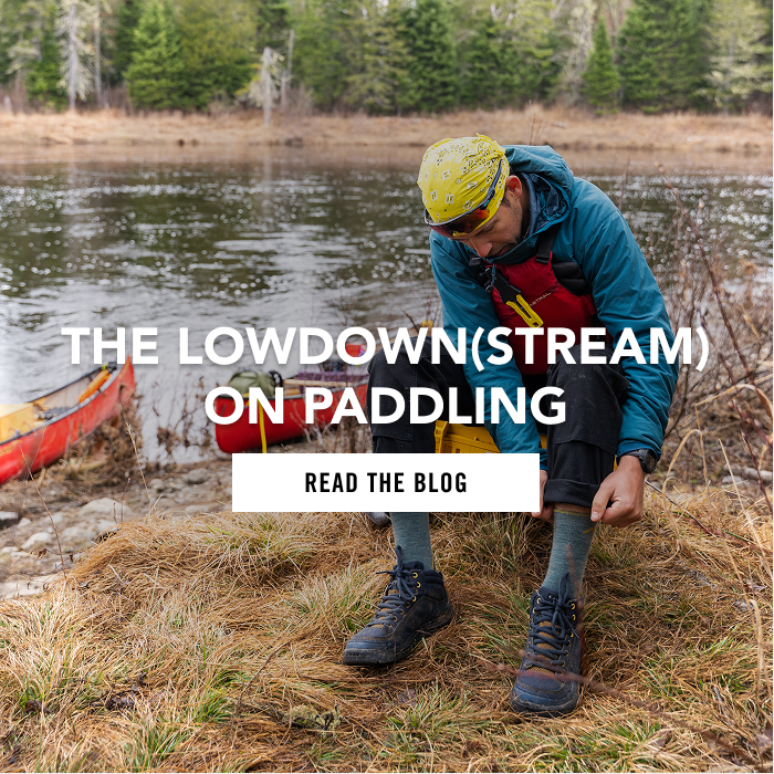 READ THE BLOG - "The Lowdown(stream) on Paddling", a paddler wearing a PDF, and wool socks on a riverbank