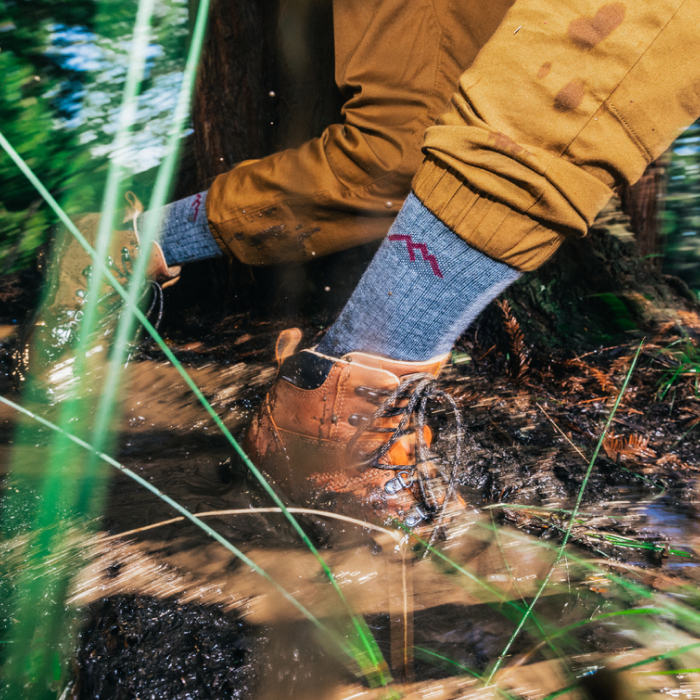 Darn It - a hiker slips into a mud puddle, luckily wearing grey Hiker Micro Crew socks